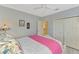 Bright bedroom with a white and pink bedspread, view to the en-suite bathroom and closet at 124 Ventana Way, Venice, FL 34292