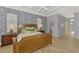Inviting bedroom with beautiful floors, patterned wallpaper, and tray ceiling at 124 Ventana Way, Venice, FL 34292