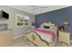 Comfortable bedroom with a light-colored bed frame, ceiling fan, and a window with white shutters at 124 Ventana Way, Venice, FL 34292