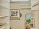 Organized walk-in closet featuring custom shelving and unique decorations on display at 124 Ventana Way, Venice, FL 34292