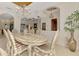Open dining room and hallway with tile flooring, traditional decor, and an ornate chandelier at 124 Ventana Way, Venice, FL 34292