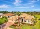 Stunning aerial view of a home with a tile roof, lush landscaping, and a well-manicured lawn at 124 Ventana Way, Venice, FL 34292
