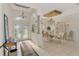 Elegant foyer leading to a dining area with a decorative chandelier, column, and tile floor at 124 Ventana Way, Venice, FL 34292