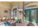 Inviting front porch featuring decorative windows, outdoor seating, and a charming green entry door at 124 Ventana Way, Venice, FL 34292