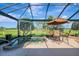 Relaxing hot tub in screened enclosure with golf course view and an outdoor dining set on the patio at 124 Ventana Way, Venice, FL 34292
