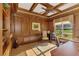 Office with wood paneled walls, coffered ceilings, and custom built-in shelves at 124 Ventana Way, Venice, FL 34292