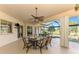 Outdoor dining area with a view of the pool and golf course beyond the screened enclosure at 124 Ventana Way, Venice, FL 34292
