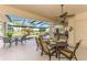 Inviting outdoor dining area with a ceiling fan, overlooking the pool and golf course at 124 Ventana Way, Venice, FL 34292