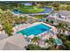 Aerial view of community pool, spa, and golf course surrounded by palm trees and waterways at 124 Ventana Way, Venice, FL 34292