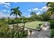 Outdoor bocce ball court surrounded by lush landscaping and mature palm trees at 2722 Sapphire Blue Ln, Bradenton, FL 34211