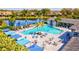 Aerial view of an expansive resort-style community pool with ample seating, shade, and a lake view at 2722 Sapphire Blue Ln, Bradenton, FL 34211
