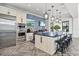 Entertaining kitchen features stainless appliances, wine cooler, island with stools, and dual TVs at 2722 Sapphire Blue Ln, Bradenton, FL 34211