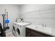 Laundry room featuring modern appliances, sink, and storage for supplies at 2722 Sapphire Blue Ln, Bradenton, FL 34211