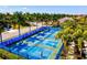 Aerial view of bright blue and green community pickleball courts surrounded by lush palm trees at 2722 Sapphire Blue Ln, Bradenton, FL 34211