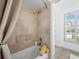 Bright bathroom featuring tiled shower and tub, with natural light from a nearby window at 3540 Bayou Cir, Longboat Key, FL 34228