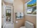Bright bathroom with marble countertop and updated fixtures. View of enclosed outdoor seating area through glass door at 3540 Bayou Cir, Longboat Key, FL 34228