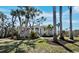 Beautiful exterior view of a single-Gathering home with mature trees, lush landscaping, and a well-manicured lawn at 3540 Bayou Cir, Longboat Key, FL 34228