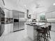 Bright kitchen features stainless steel appliances, custom cabinets, large island and white tile flooring at 3540 Bayou Cir, Longboat Key, FL 34228