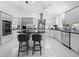 Modern kitchen features stainless steel appliances, custom cabinets, an island with seating and white tile flooring at 3540 Bayou Cir, Longboat Key, FL 34228