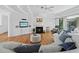 Bright living room with hardwood floors, a cozy fireplace, a modern ceiling fan, and a plush white sofa at 3540 Bayou Cir, Longboat Key, FL 34228