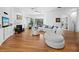 Spacious living room featuring hardwood floors, a fireplace, a ceiling fan, and a comfortable white sofa at 3540 Bayou Cir, Longboat Key, FL 34228