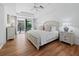 Bright main bedroom features wood floors, a ceiling fan, balcony access, and a luxurious king-size bed at 3540 Bayou Cir, Longboat Key, FL 34228