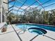 Screened-in pool featuring a spa and a seating area surrounded by lush greenery, perfect for relaxation and entertainment at 3540 Bayou Cir, Longboat Key, FL 34228