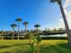 Waterfront property with a lush lawn, tropical landscaping, and a dock with boat lift along a canal at 4430 Wynkoop Cir, Port Charlotte, FL 33948