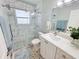 Updated bathroom features a glass enclosed shower, vanity, and marble-tiled walls at 4430 Wynkoop Cir, Port Charlotte, FL 33948