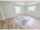 Bright bedroom features wood-look floors, two windows, a ceiling fan and a large rug at 4430 Wynkoop Cir, Port Charlotte, FL 33948