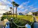 Picturesque waterfront property featuring a well-manicured lawn, mature palms, and a charming shed at 4430 Wynkoop Cir, Port Charlotte, FL 33948