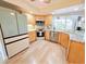 Bright kitchen features wood cabinets, stainless appliances, and a large window overlooking the pool at 4430 Wynkoop Cir, Port Charlotte, FL 33948