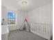 Bright Bedroom features a modern chandelier, window, and a white crib with a playful teepee tent at 4886 Seafoam Trl, Bradenton, FL 34211