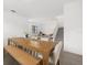 Open dining area with a large wooden table, seamlessly connected to the living room and staircase at 4886 Seafoam Trl, Bradenton, FL 34211
