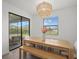 Dining room features a stylish chandelier, a wooden table with bench, and sliding glass doors at 4886 Seafoam Trl, Bradenton, FL 34211