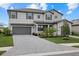 Two-story home featuring a gray exterior, well-manicured landscaping, and a paver driveway at 4886 Seafoam Trl, Bradenton, FL 34211