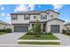 Two-story home with symmetrical design, gray siding, 2-car garage, manicured lawn, and brick paver driveway at 4886 Seafoam Trl, Bradenton, FL 34211