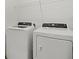 Bright laundry room featuring modern washer, dryer, and wire shelving at 4886 Seafoam Trl, Bradenton, FL 34211