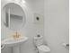 Stylish powder room featuring a pedestal sink with gold fixtures and a modern toilet at 4886 Seafoam Trl, Bradenton, FL 34211