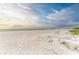 Scenic sandy beach scene with distant ocean horizon under a tranquil sky, inviting peaceful relaxation at 5200 Gulf Dr # 601, Holmes Beach, FL 34217