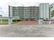 Exterior of condo building with brick entrance and lush landscaping at 5200 Gulf Dr # 601, Holmes Beach, FL 34217