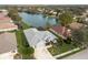 Aerial view of the home with a lake view, well-manicured lawn and landscaping at 5383 Creekside Trl, Sarasota, FL 34243