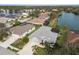 Aerial view of the home with a lake view, well-manicured lawn and landscaping at 5383 Creekside Trl, Sarasota, FL 34243
