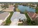 Aerial view of the home with a lake view, well-manicured lawn and landscaping at 5383 Creekside Trl, Sarasota, FL 34243