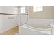 Bright bathroom features white tile walls, mosaic accents, glass-enclosed shower, and a separate soaking tub beneath a window at 5383 Creekside Trl, Sarasota, FL 34243