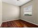 Inviting bedroom with gleaming wood floors, neutral walls, and a bright window offering natural light at 5383 Creekside Trl, Sarasota, FL 34243