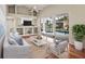 Bright living room with vaulted ceilings, built-in shelves, hardwood floors, and sliding glass doors to the pool at 5383 Creekside Trl, Sarasota, FL 34243