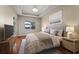 This main bedroom boasts wood floors, a ceiling fan, a sitting area, and views of the lanai at 5383 Creekside Trl, Sarasota, FL 34243