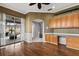 Well-lit office features rich wood floors, built-in wood cabinets, and a sliding glass door to the pool and lanai at 5383 Creekside Trl, Sarasota, FL 34243