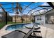 Screened-in pool with a fountain, lounge chairs, and a view of the backyard at 5383 Creekside Trl, Sarasota, FL 34243